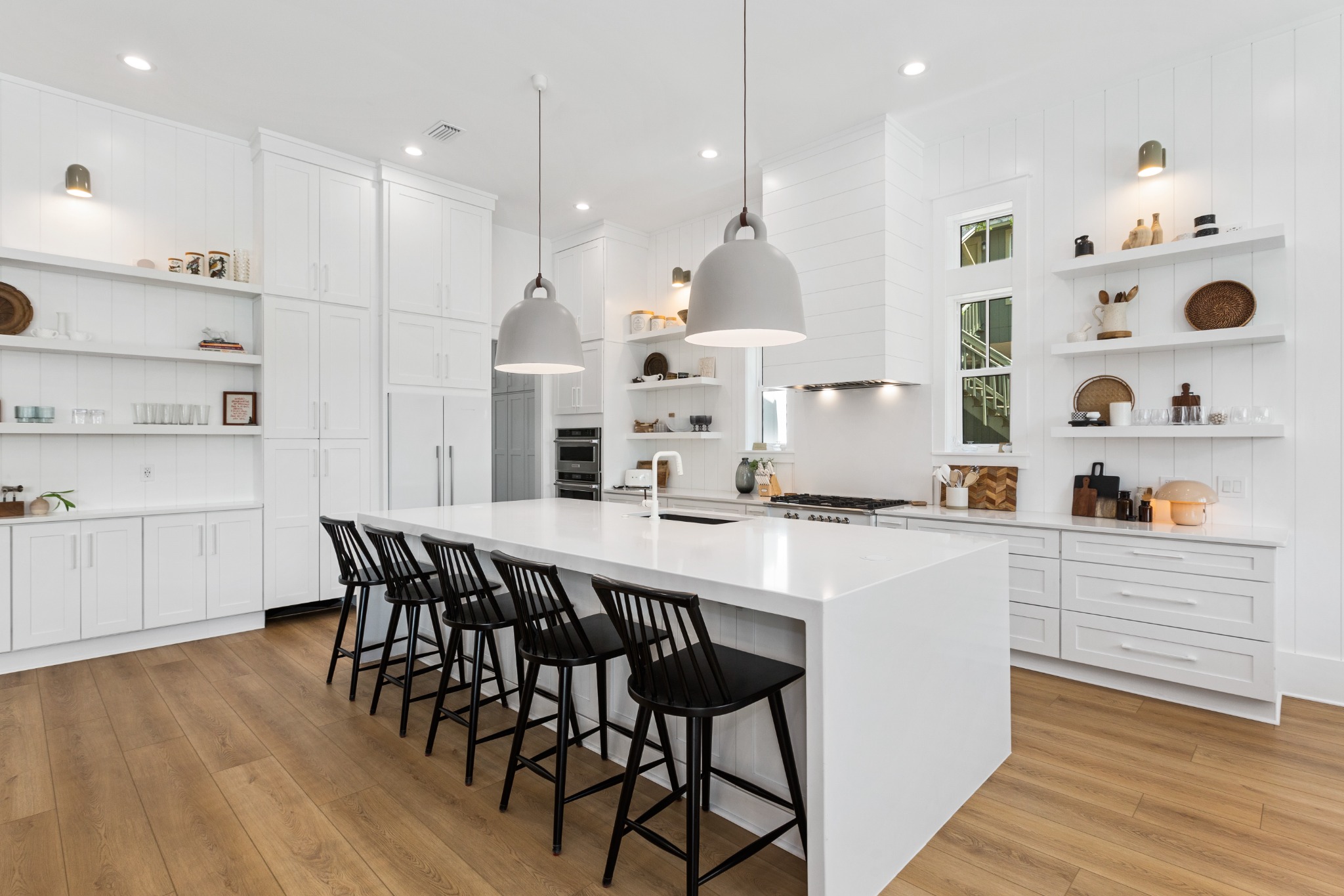 Chef's kitchen with marble island and bar stools