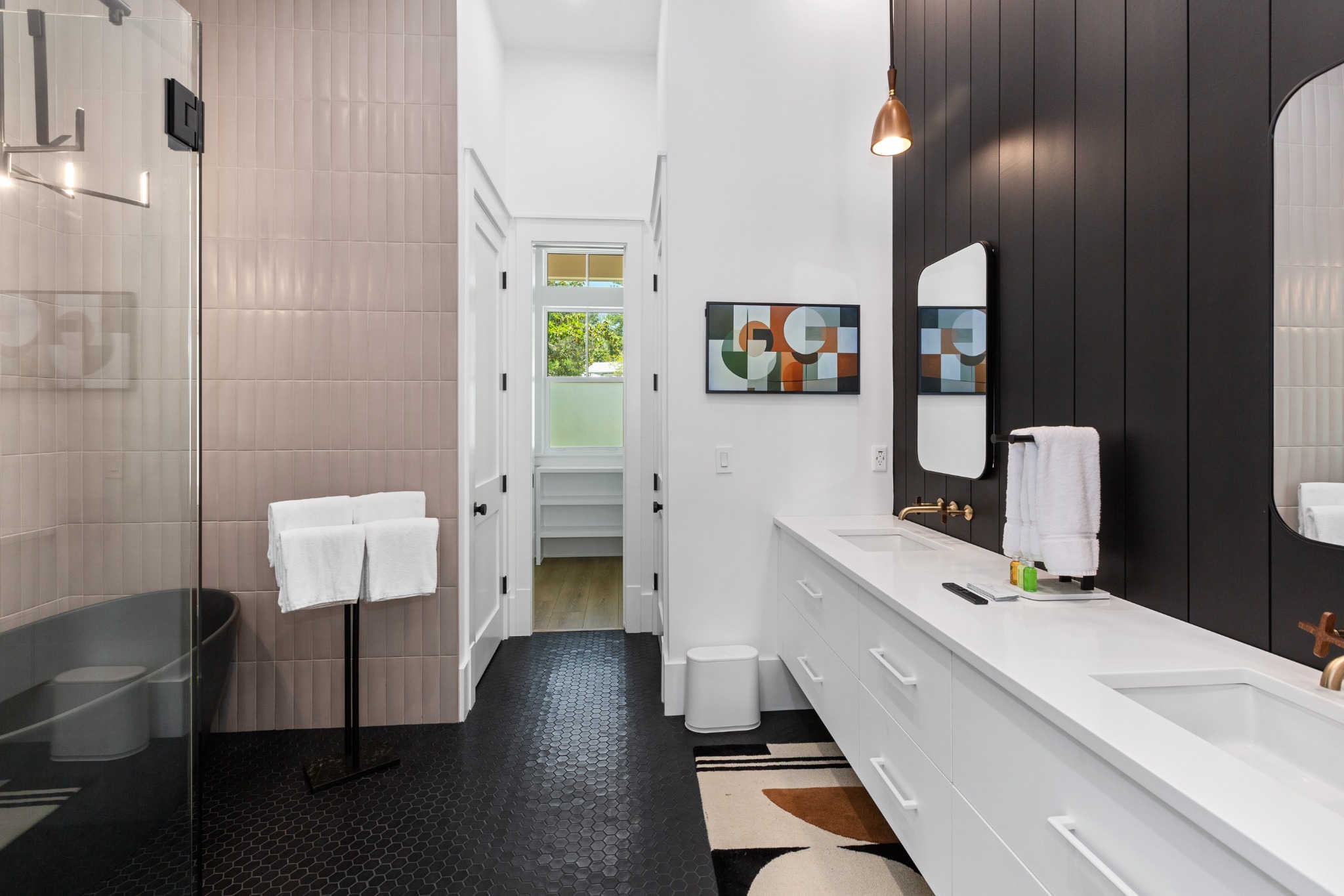Bathroom with double vanity against a deep black accent wall